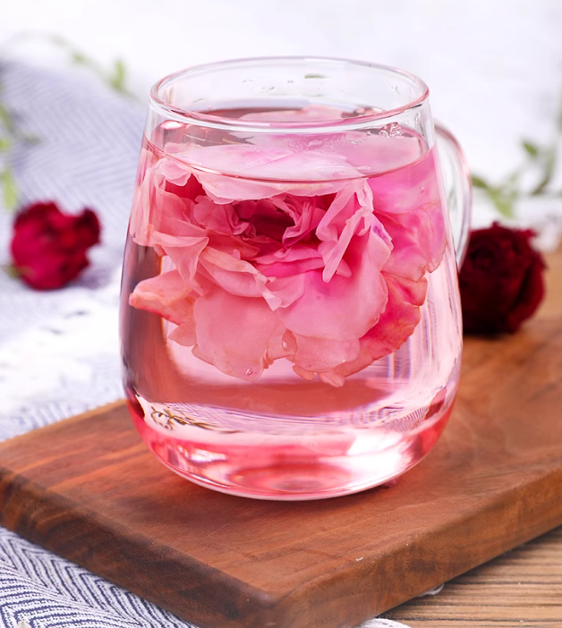 Glass mug with pink flowers on a wooden board