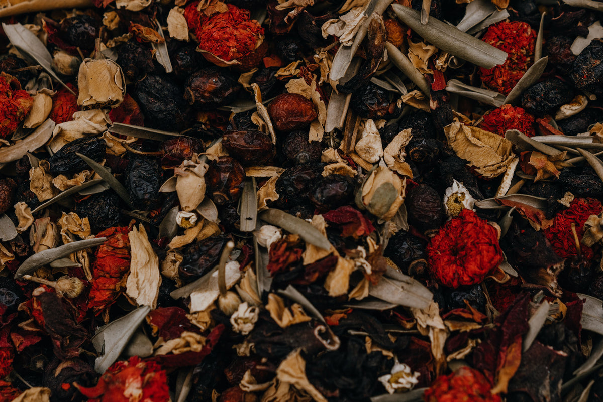 Close-up of a mix of dried herbs and flowers with red and orange colors.